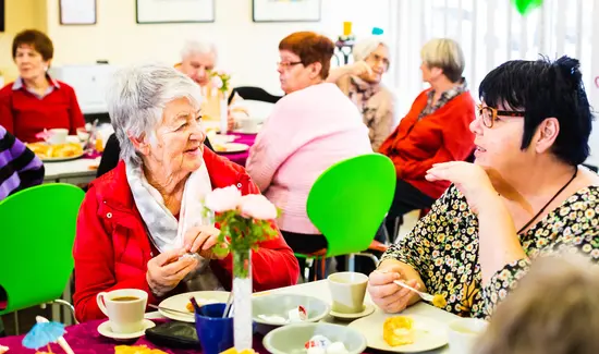Gruppe von fröhlichen Menschen im Cafe Trio