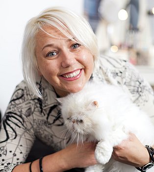 Blonde Frau kuschelt mit weißer Katze