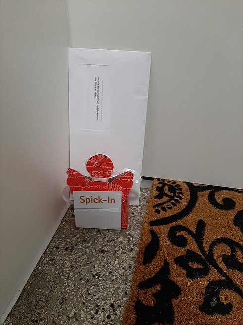 Weihnachtsengel mit Brief und Grußkarte vor Wohnungstür 