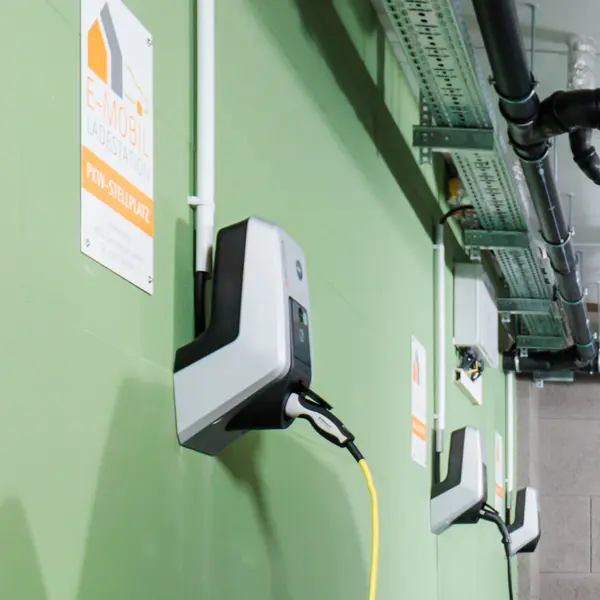Kleiner Junge vor ladendem Auto an einer E-Mobil Ladestation