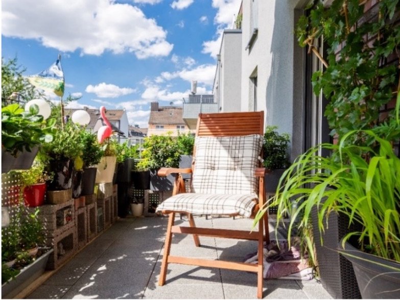 Musterbalkon der WSG Balkon mit vielen Pflanzen und Liegestuhl