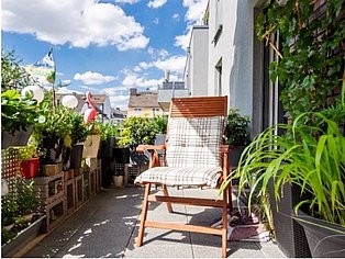 Musterbalkon der WSG Balkon mit vielen Pflanzen und Liegestuhl