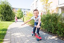 [Translate to English:] Kinder in einer Wohnsiedlung der WSG auf Skateboards