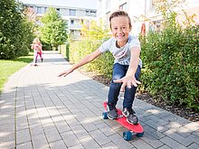 Kinder in einer Wohnsiedlung der WSG auf Skateboards