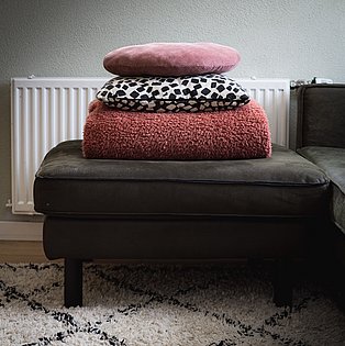 Decken und Kissen gestapelt auf einem Sofa