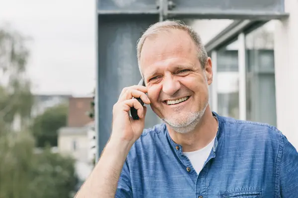 Mann im Leinenhemd telefoniert