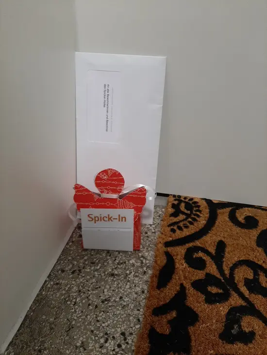 Weihnachtsengel mit Brief und Grußkarte vor Wohnungstür