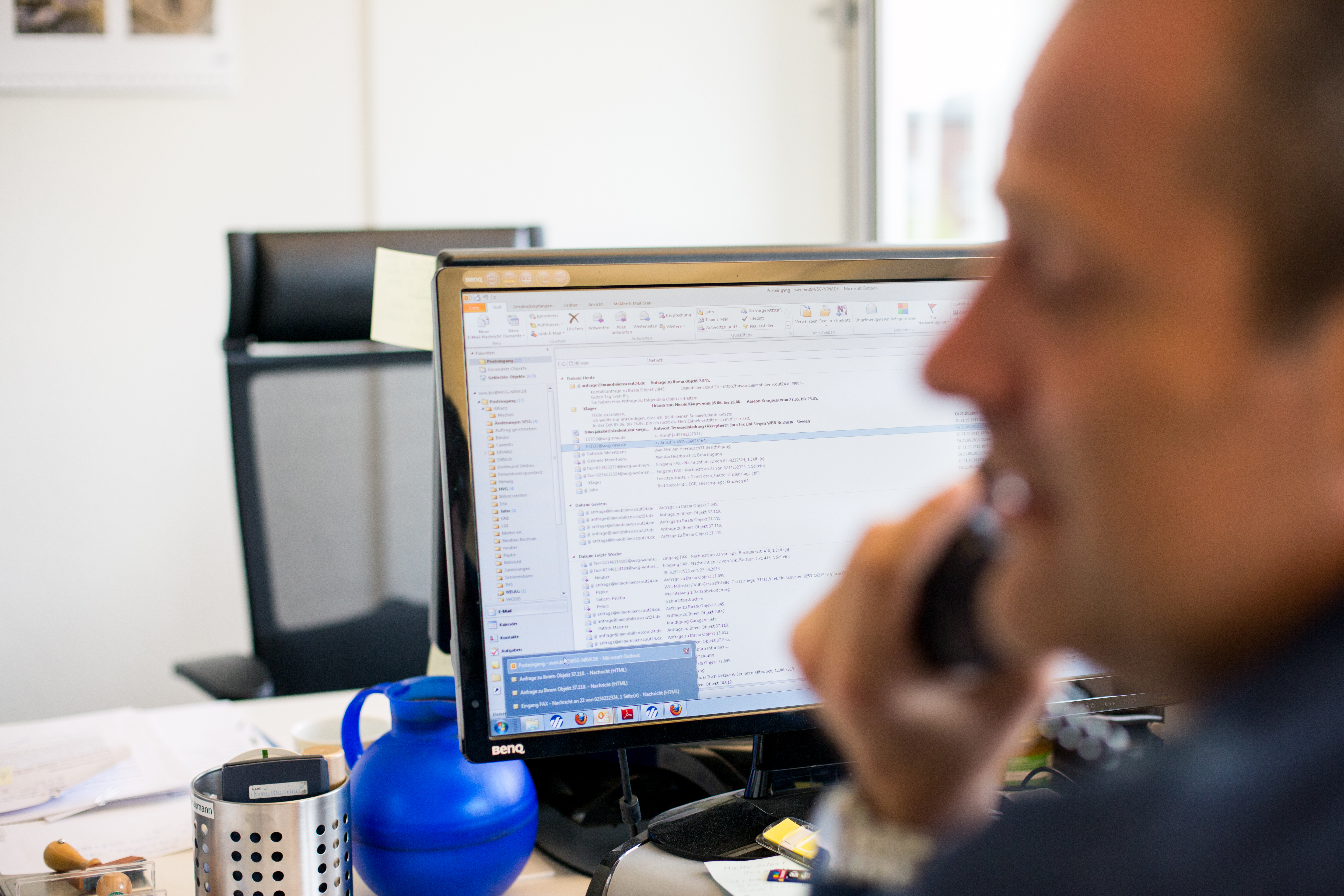 Mann sitzt vor Rechner mit geöffnetem Emailprogramm